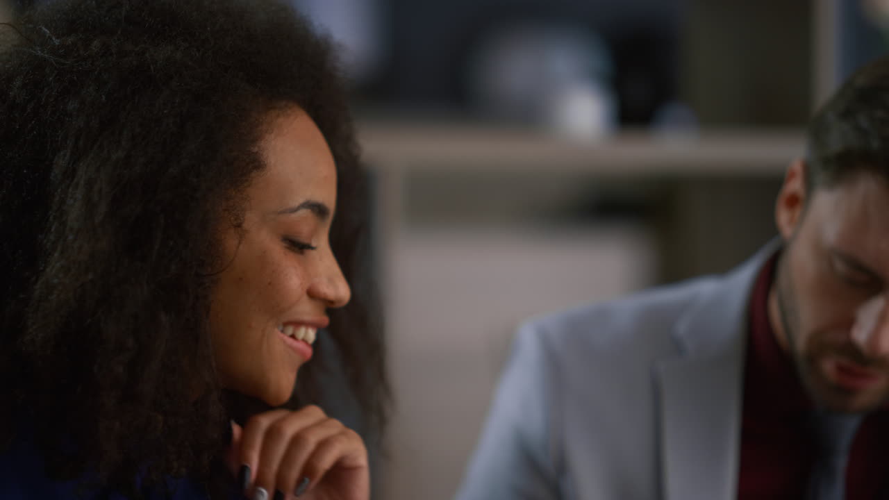Multiracial colleagues laughing working together share ideas in office building.