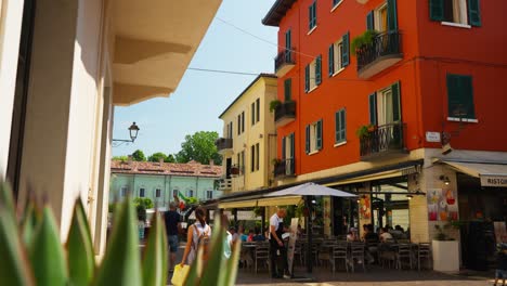 restaurant with outdoor dining on sunny day in old town of peschiera del garda, veneto, italy. wide shot