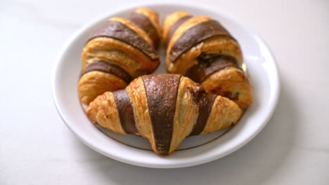 fresh croissant with chocolate on plate