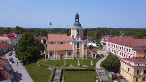 woman with red dress sits in front of hill church