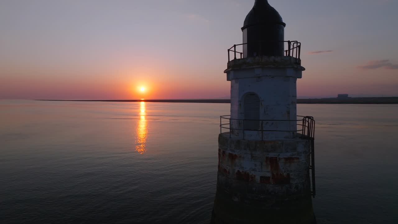 Old lighthouse in very calm waters at sunset. Close up. Plover Scar Lighthouse, Lancashire, UK.