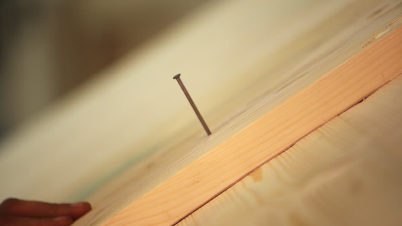 Man hammering a nail into a piece of wood