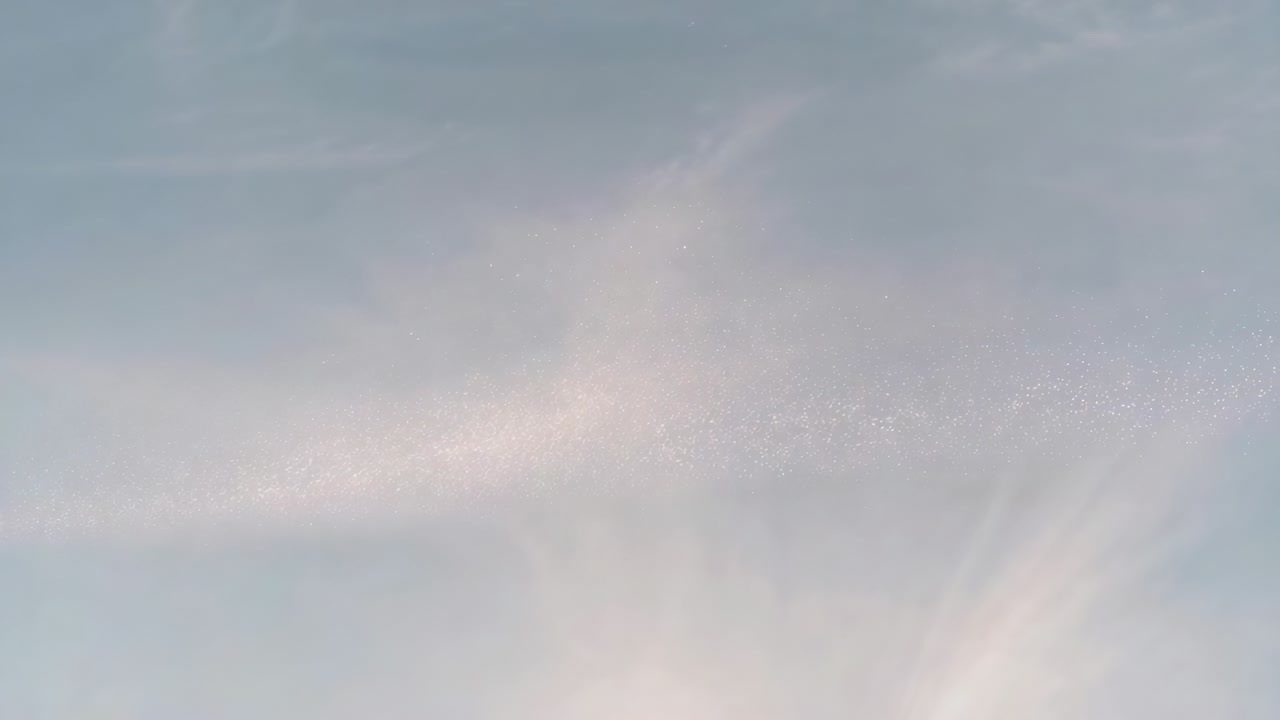 Recording cam observing blue sky from ground with lower glow, drifting wispy cirrus and speck band