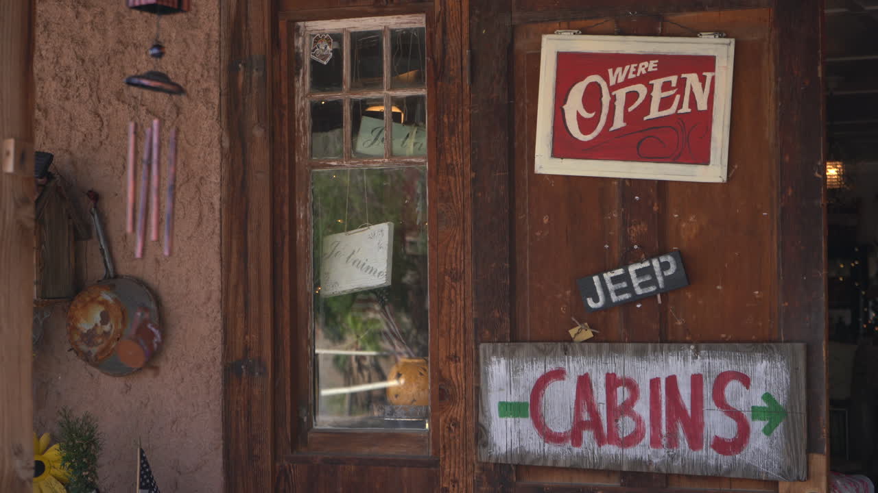 Porta rustica in legno con cartelli "Aperto" e "Cabine"