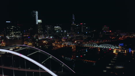 Beautiful-night-aerial-of-Nashville-TN-moving-over-Korean-Veterans-bridge,-4K