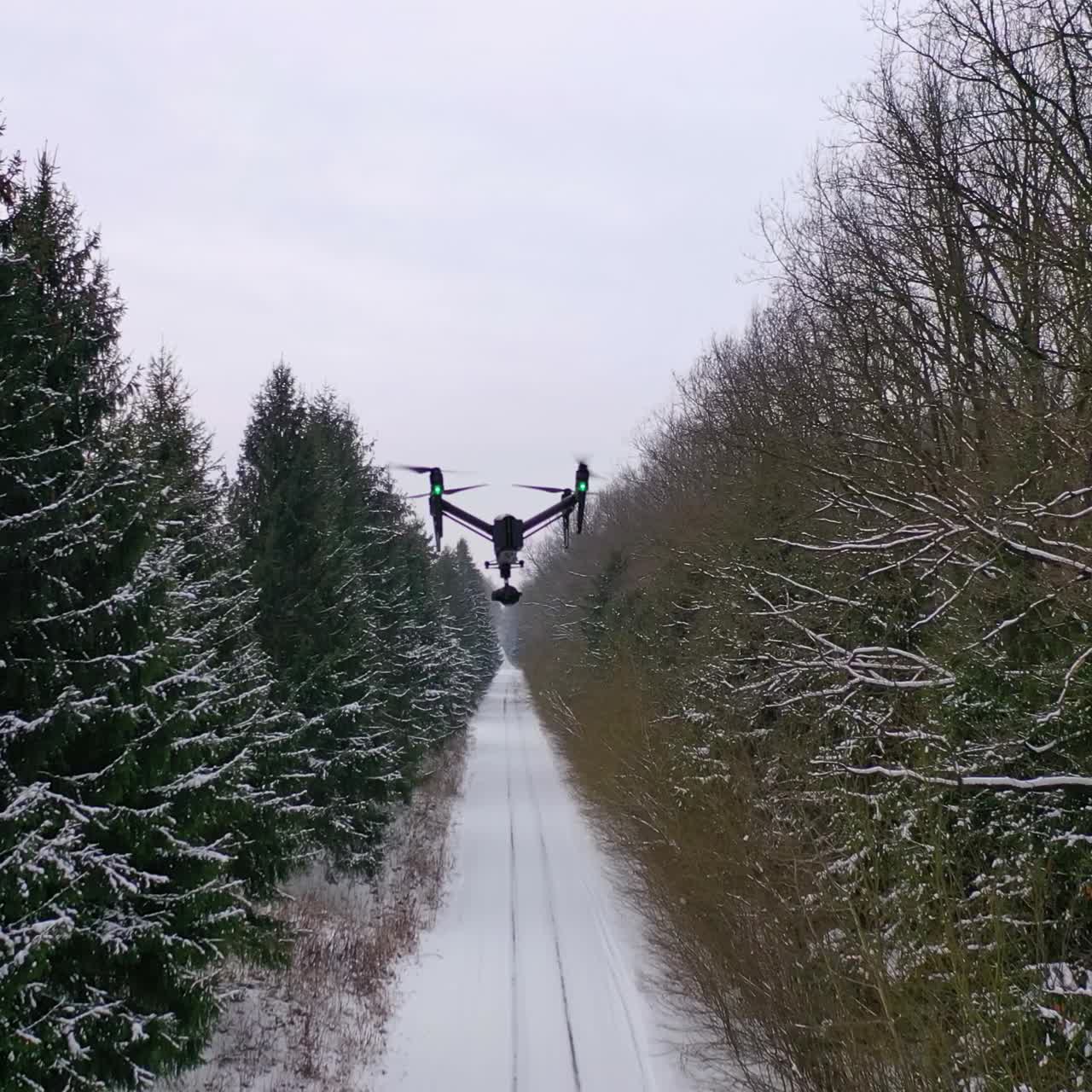 Winter road in forest. Drone is flying over the snowy road in the sky. Winter landscape. Drone among beautiful scenery