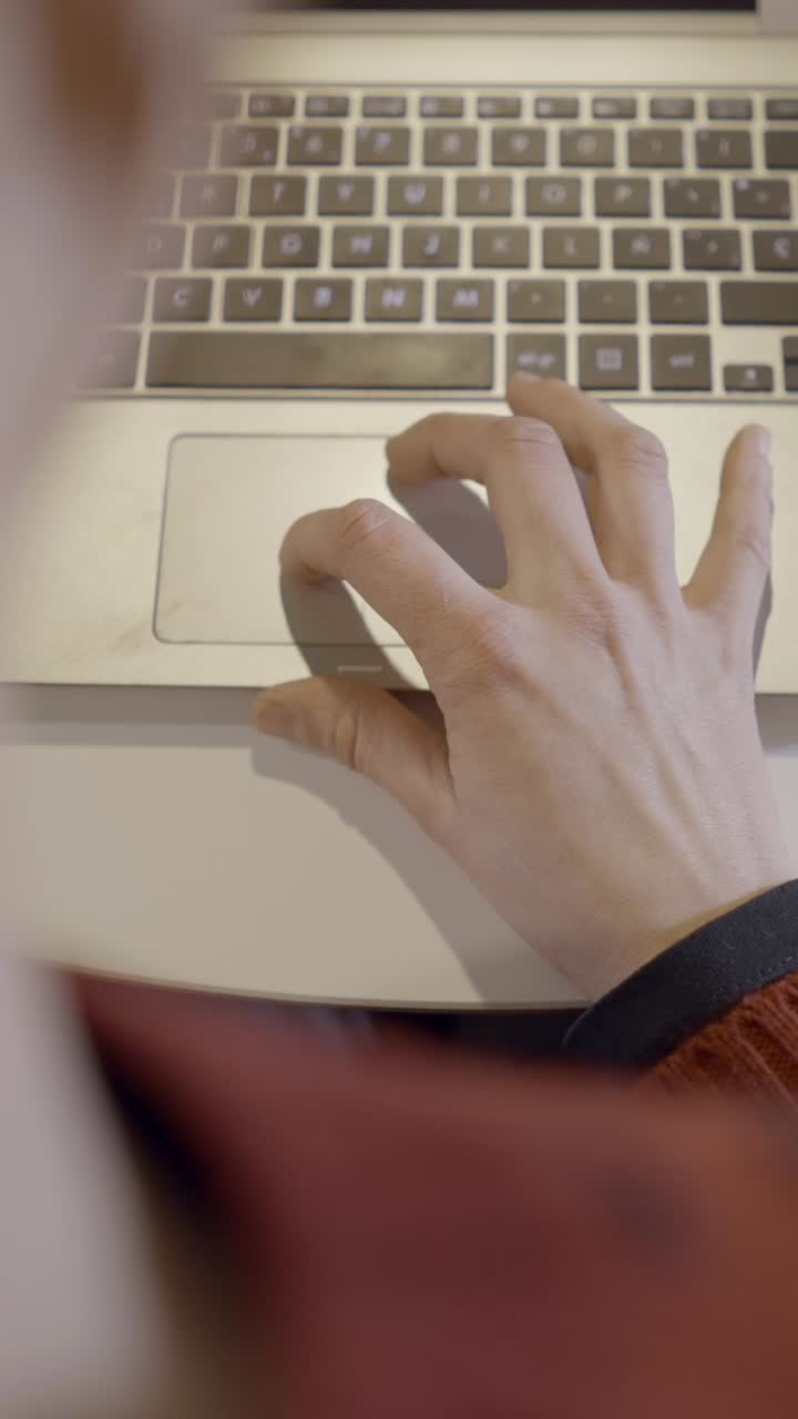 Close-up of a hand using a laptop trackpad