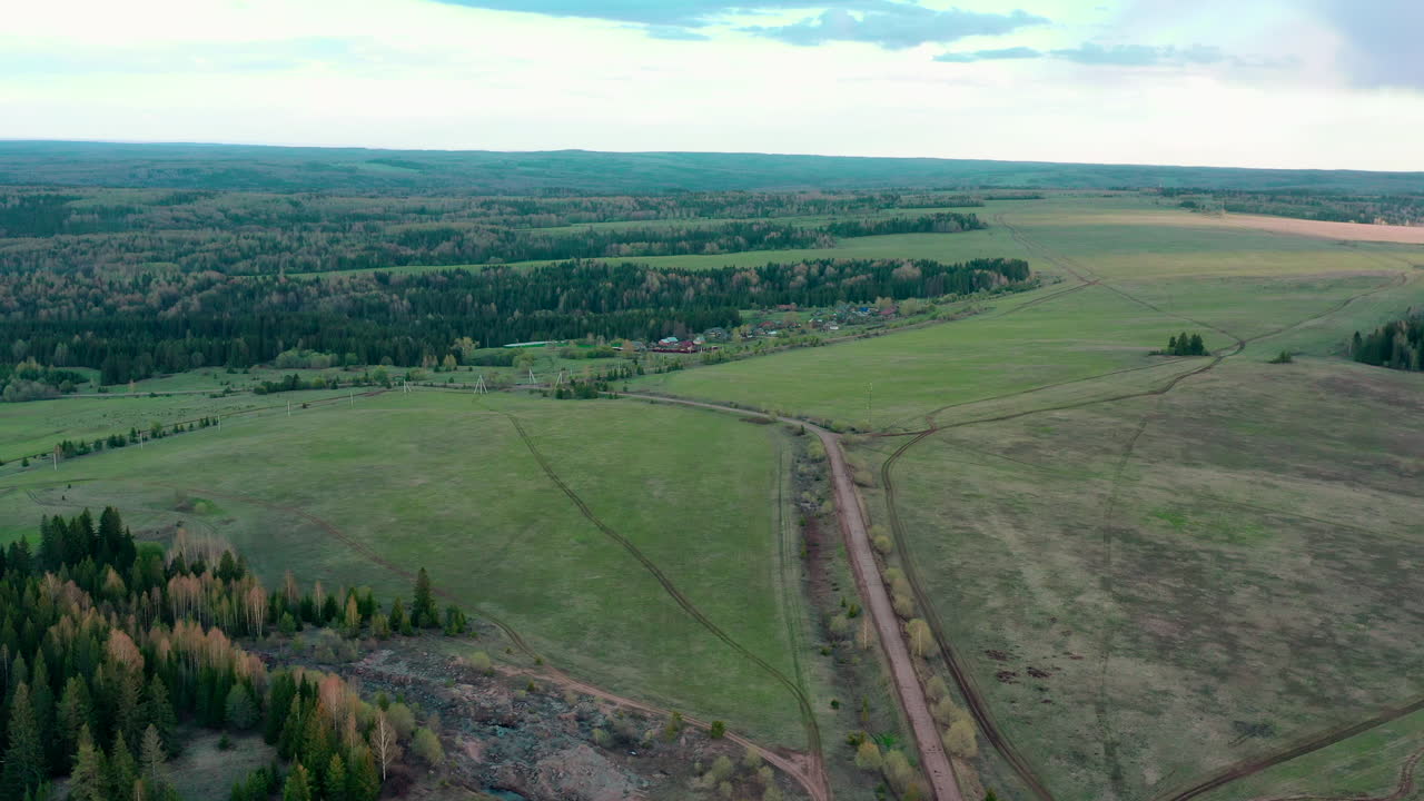 vista aérea de un paisaje rural con campos, bosque y una aldea