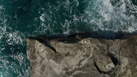 Aerial-Overhead-Top-Down-Birds-Eye-View-of-Big-Ocean-Waves-crashing-on-Rocks