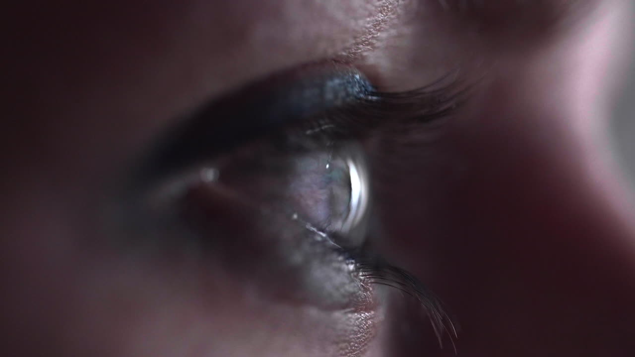 vista lateral de un ojo femenino navegando por un smartphone - toma macro