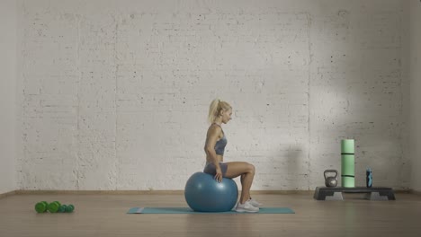 mujer haciendo ejercicios de fitness con una pelota de fitness