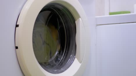 washing colored clothes in household washing machine. rotating drum. 4k