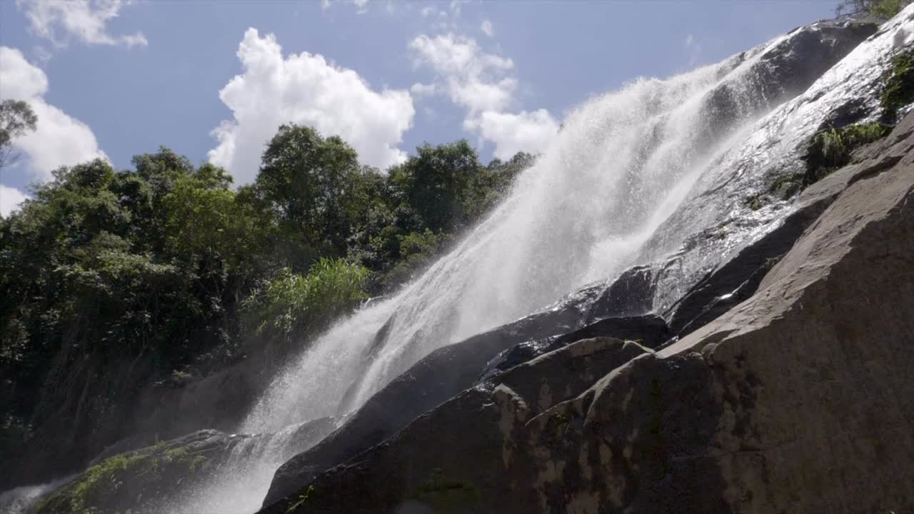 rociado de agua a cámara lenta que fluye sobre terreno rocoso