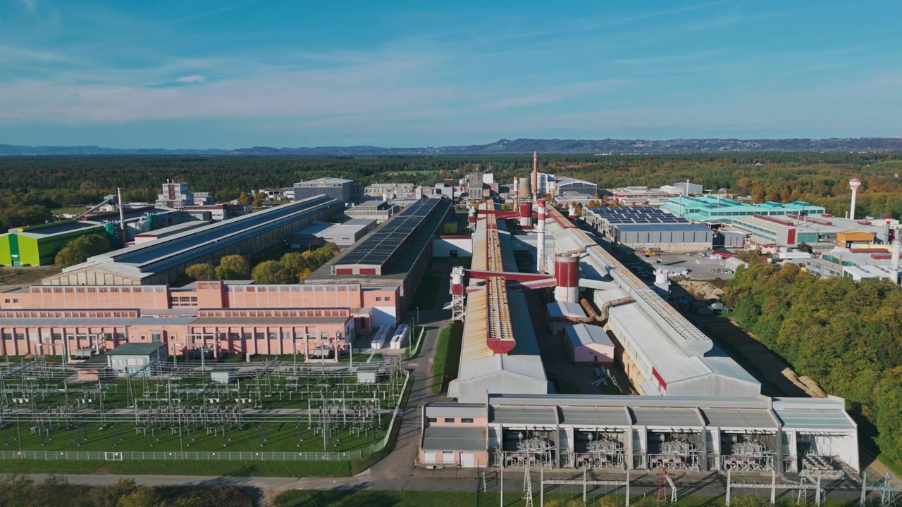 This aerial view shows a large aluminum factory with surrounding industrial buildings and landscape