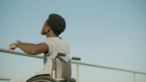 low angle shot of young man dancing in wheelchair outside