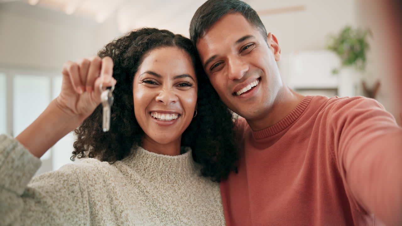 Selfie of happy couple in living room with keys to