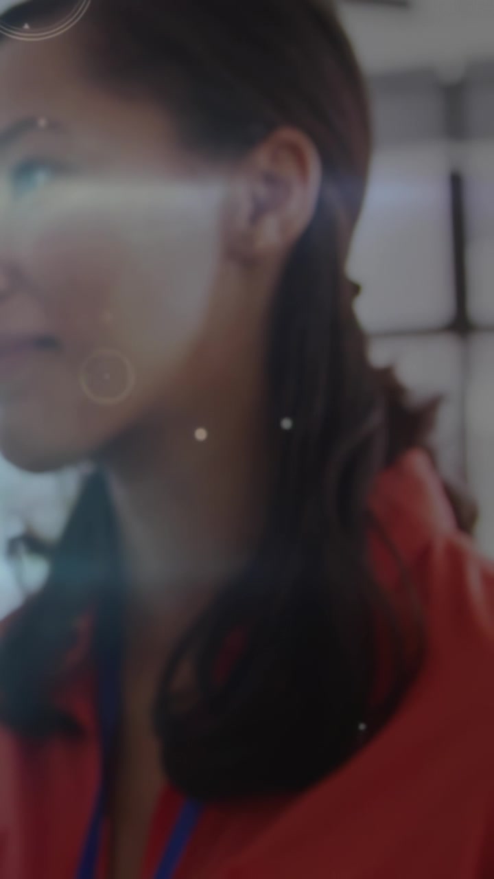 Vertical video: Adult woman gesturing and speaking in event while camera pulling back revealing HUD