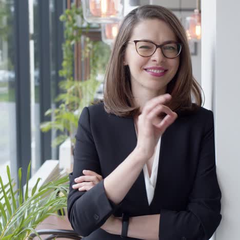 portrait of young smiling businesswoman standing in modern office interior