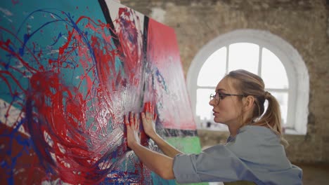 innovative artist draws with her hands on the large colorful canvas, emotional, sensual painting