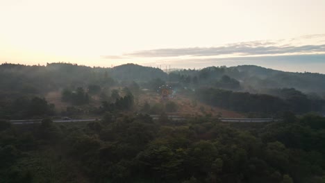 Aerial-panoramic-landscape-of-amusement-park-ferris-wheel-abandoned-at-kejonuma-leisure-island-Japan-Japanese-outskirts-countryside-mountain-background-sunset-skyline