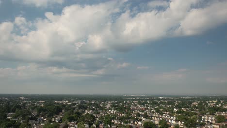 un lapso de tiempo aéreo sobre un barrio suburbano tranquilo en un día soleado con cielos azules con nubes blancas