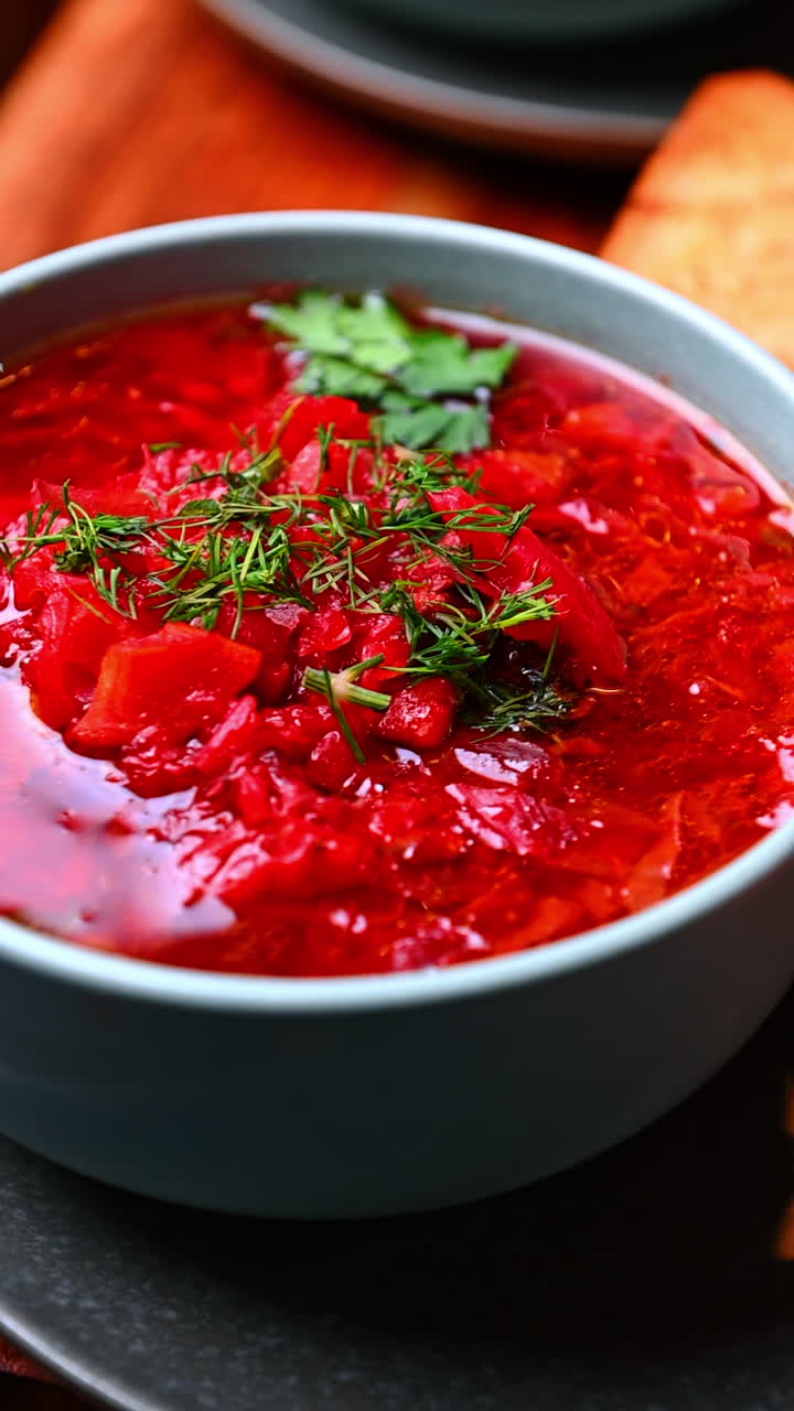 Bright beet soup closeup view. Rich beet soup with herbs in a bowl captured in vibrant detail