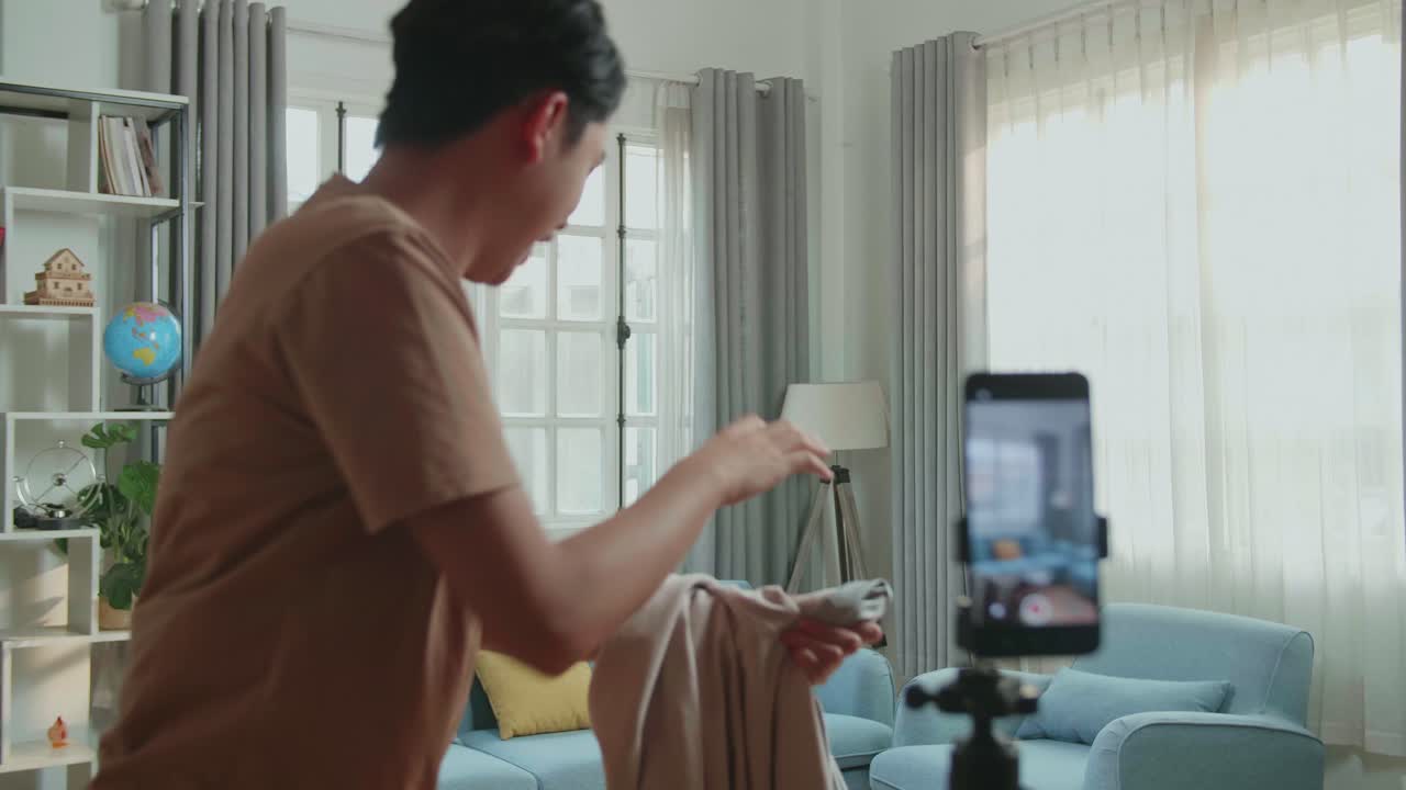 Man making a funny video recording himself in the living room