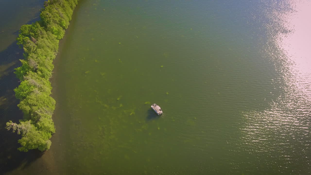 An aerial view of a pontoon boat sitting on a lake