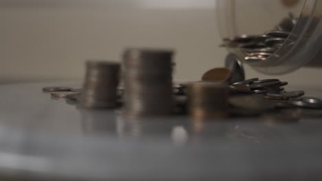 adding various coins to a pile in slow motion