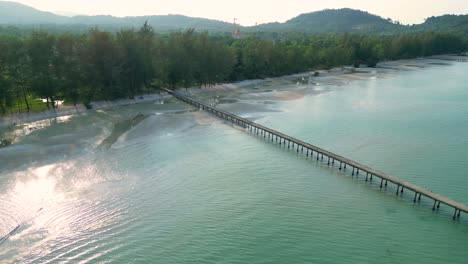 Aerial View of a Long Pier Extending into Turquoise Waters along a Tropical Coastline