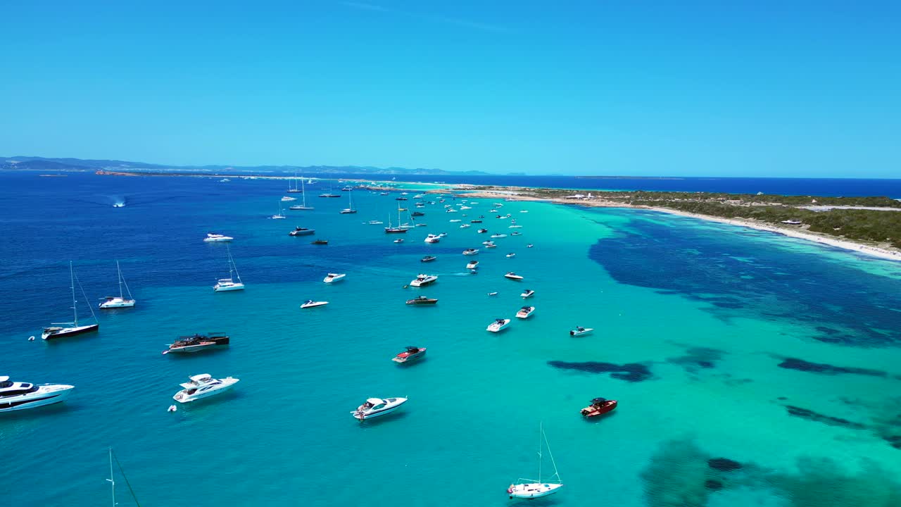 Hyperlapse con rampa di velocità di molte imbarcazioni da diporto ancorate nelle acque turchesi cristalline di Formentera, isola delle Baleari. Fantastica ripresa aerea panoramica orbitale con drone