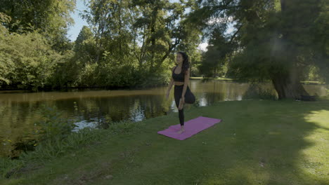 Pretty-Young-woman-doing-tree-pose-in-beautiful-green-park