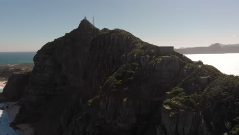 amplia vista aérea ascendente de enormes acantilados junto a las playas de cape point en sudáfrica