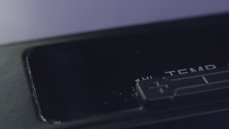 a detailed tilt up macro shot, of a black electronic hair straightener, close up on the temperature and power buttons, hairstyle equipment, purple background, professional studio lighting, 4k video