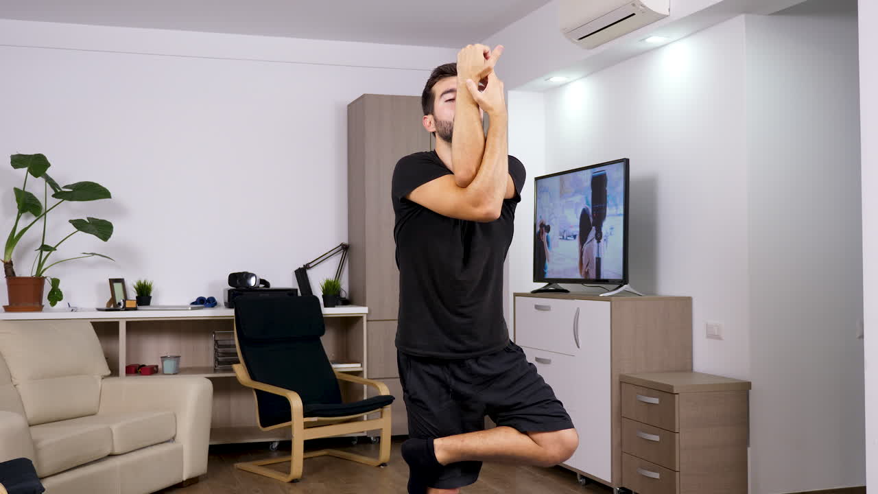 Man practicing yoga in living room