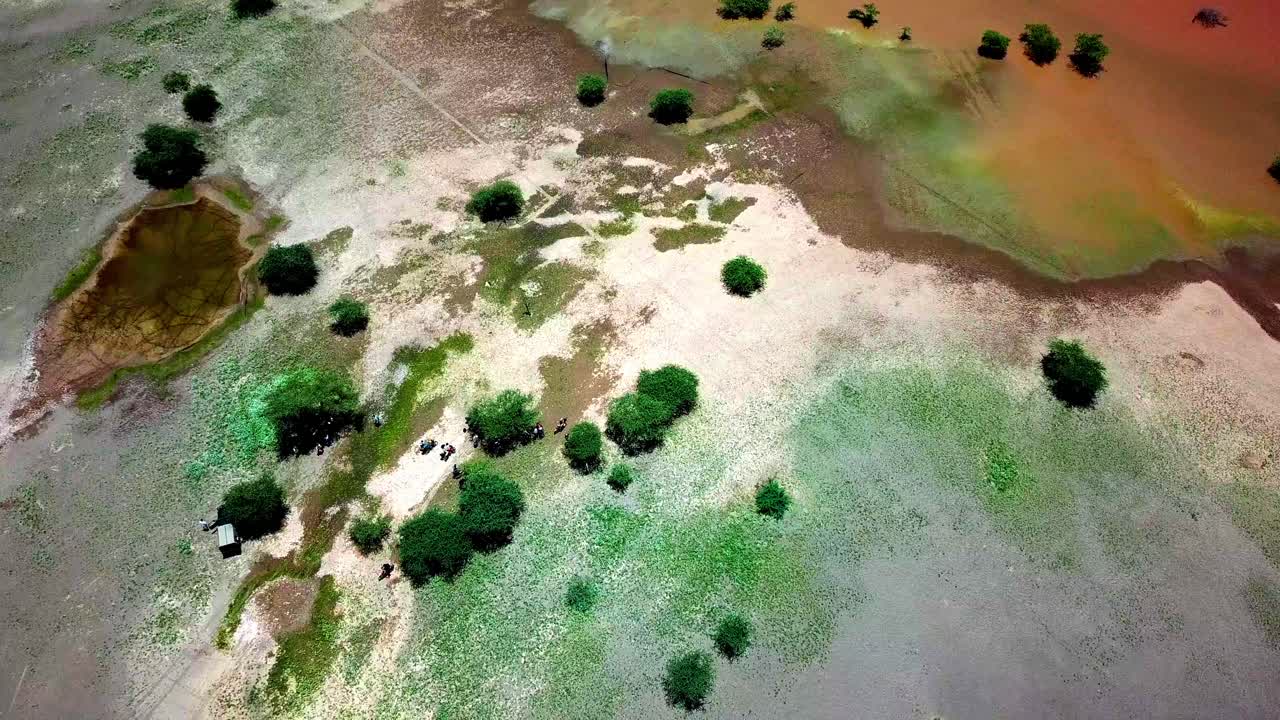 Motociclistas activos reunidos bajo la sombra de árboles de acacia alrededor del lago Magadi en el Gran Valle del Rift, Kenia, África