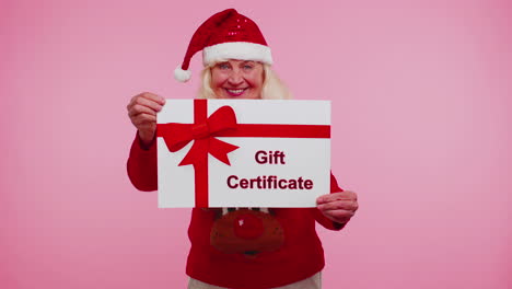 Senior-grandmother-woman-in-New-Year-sweater-presenting-card-gift-certificate-coupon-winner-voucher