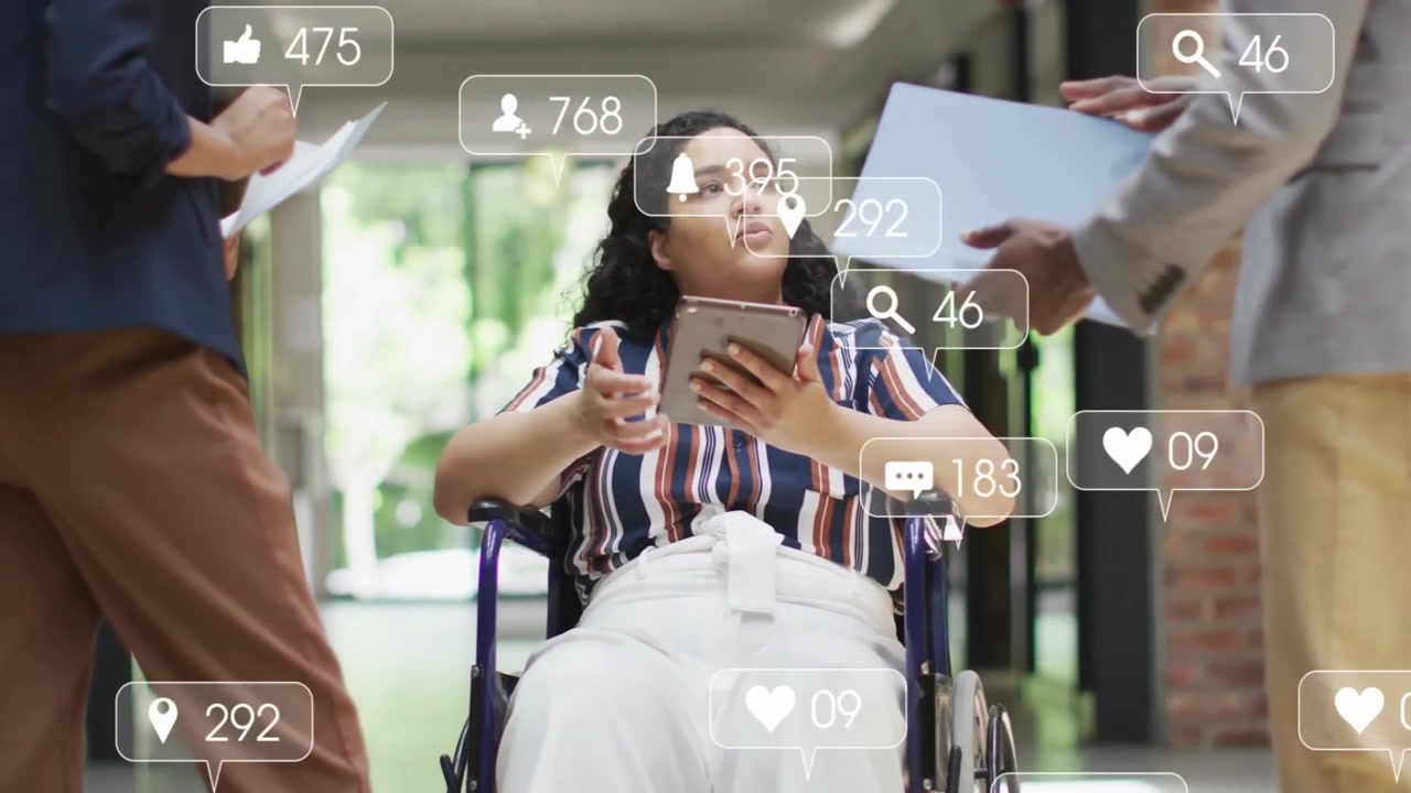 Woman in wheelchair tapping tablet tracking social icons fluctuating around screen for marketing