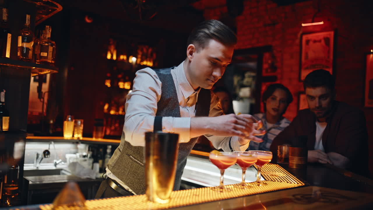 Bartender che decora cocktail al bancone di un ristorante di lusso, primo piano. Barman esperto
