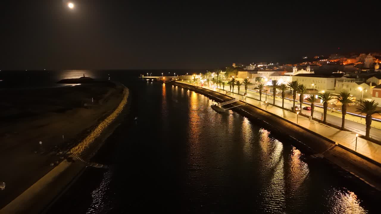 Night drone view of moonlit promenade and waterfront in Lagos Portugal