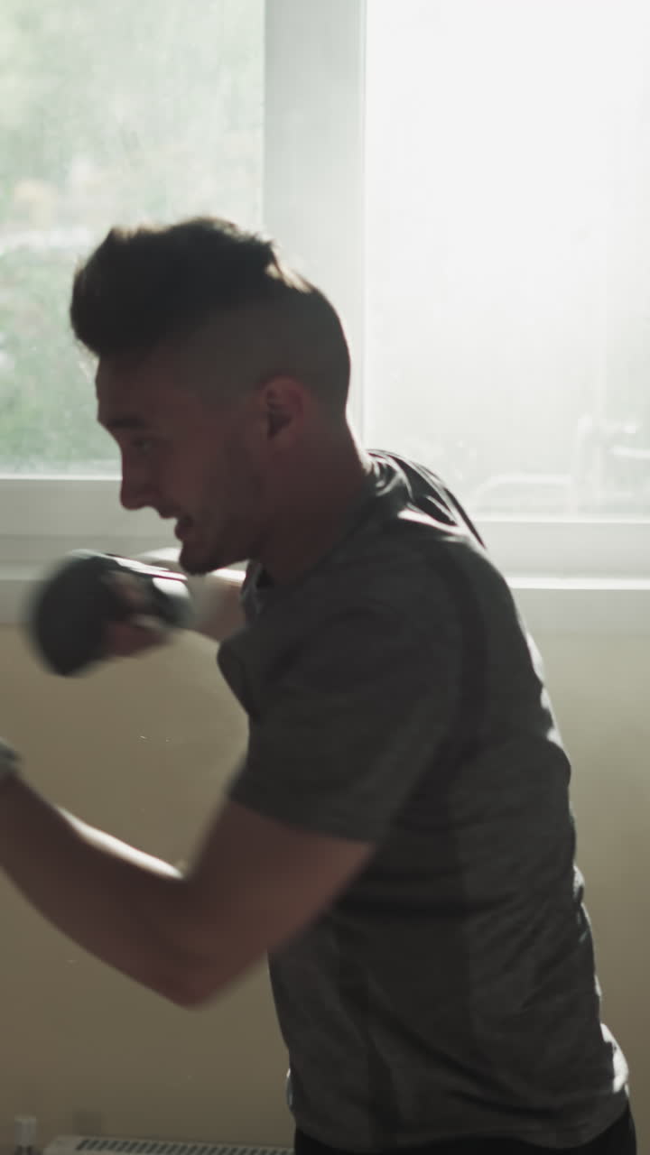 Athletes exercise with punching bags in sports club. Skilled sportsmen silhouettes kick and punch heavy equipment in fighting gym slow motion. Martial arts team