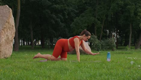mujer embarazada haciendo yoga al aire libre