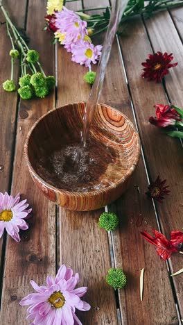 watering flowers on a wooden table