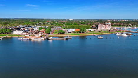 approaching a beautiful waterfront of the markermmer lake, lelystad,the netherlands. large ship batavia at museum batavialand is at the pier. aerial view.