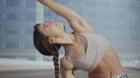 Woman-doing-reverse-warrior-yoga-pose-on-street.-Lady-stretching-hands-outdoors