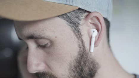 hombre poniéndose auriculares para escuchar música en casa