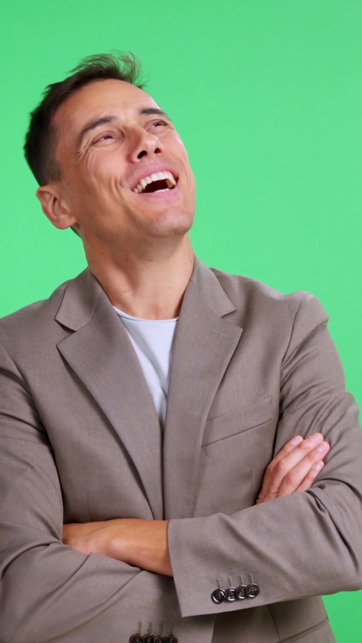 Uomo d'affari allegro che sogna e guarda in alto su green screen