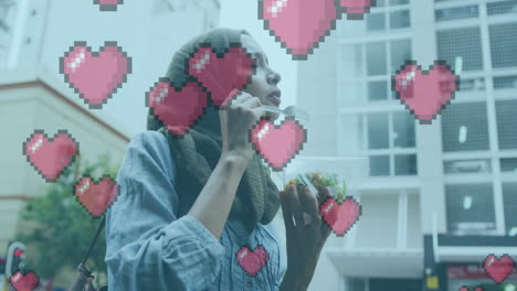 animation of love heart icons with woman in hijab eating in city street