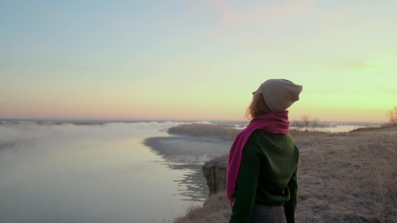 Woman enjoying a beautiful sunrise over a misty river valley
