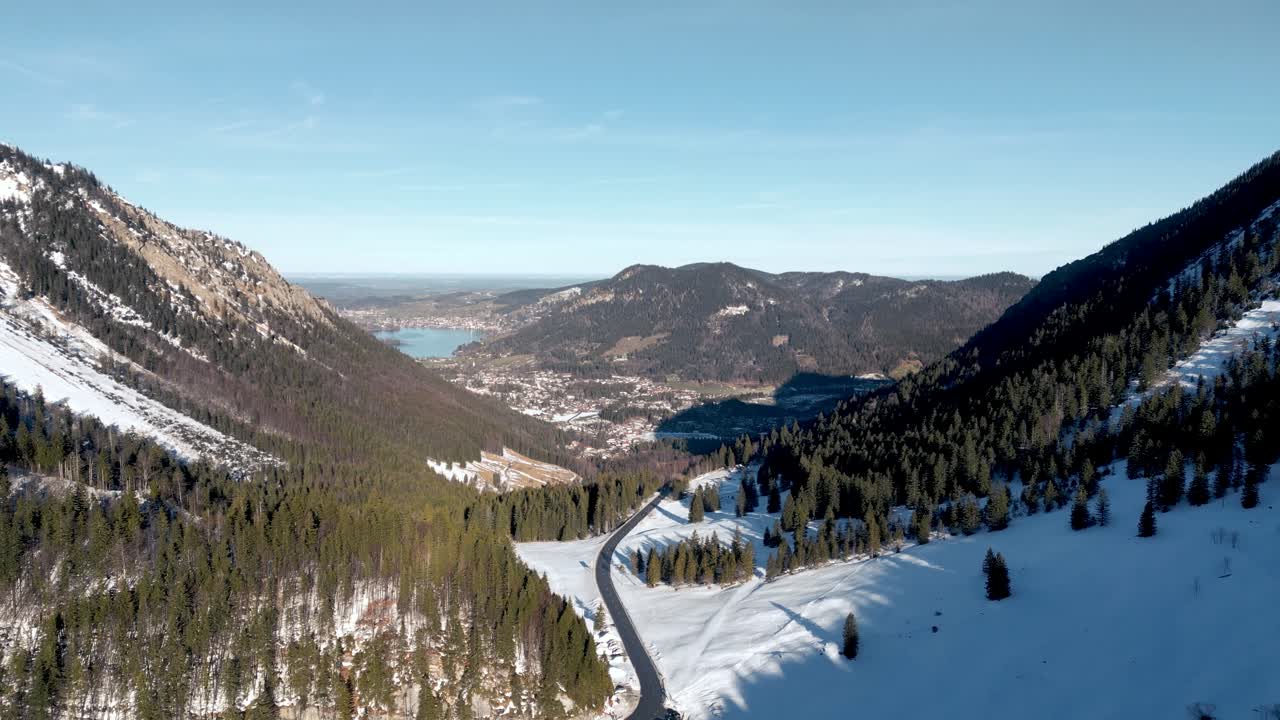 impresionante vista aérea desde un avión no tripulado: paso de montaña cubierto de nieve, vista panorámica del schliersee en alemania, paisaje de los alpes bávaros con carretera y lago de montaña lejano en la temporada de invierno